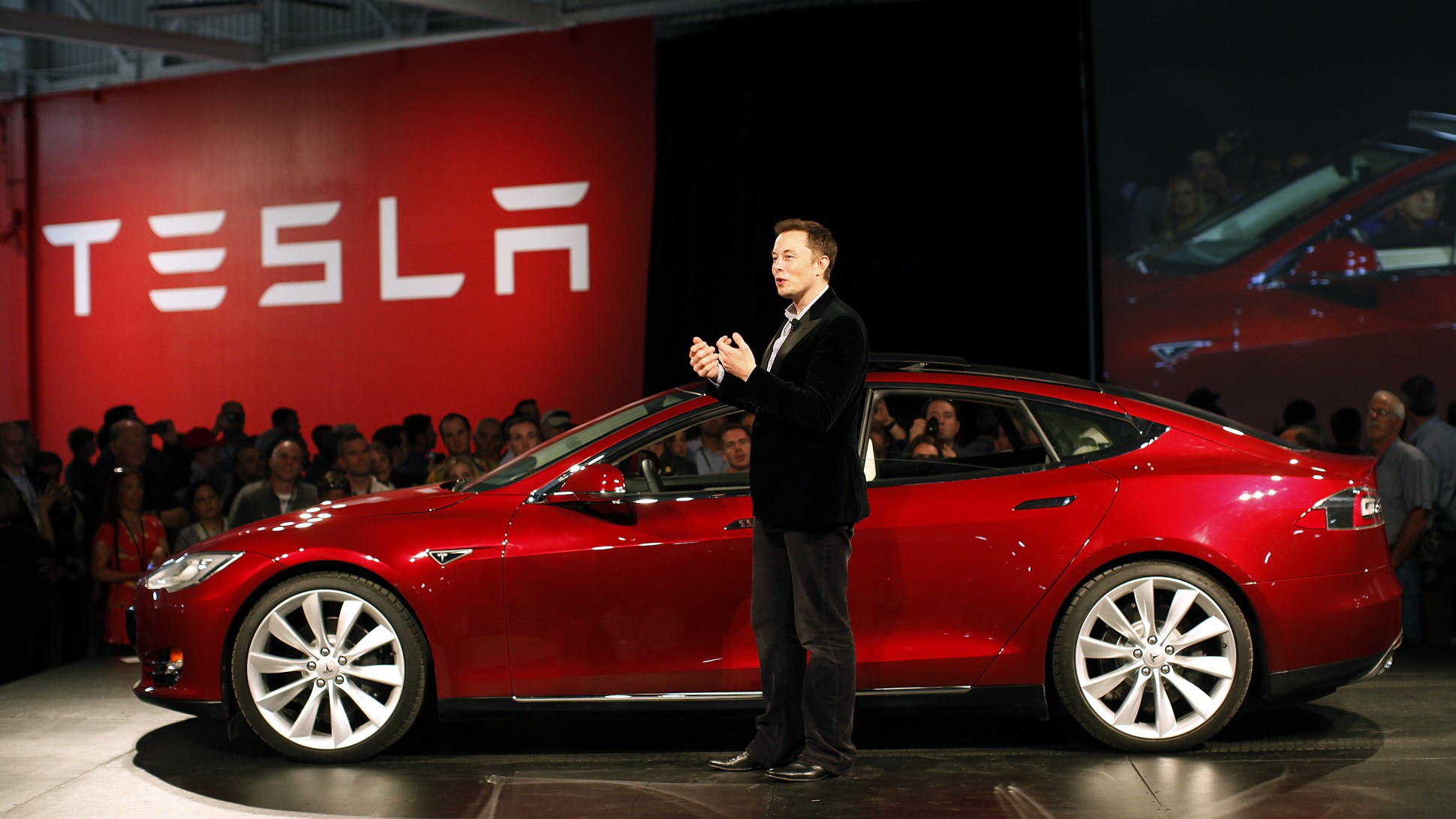 elon musk in front of a tesla motor vehicle